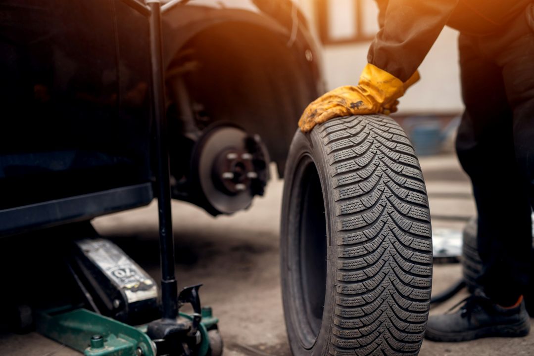 mechanic inspecting a used car tire before replacement
