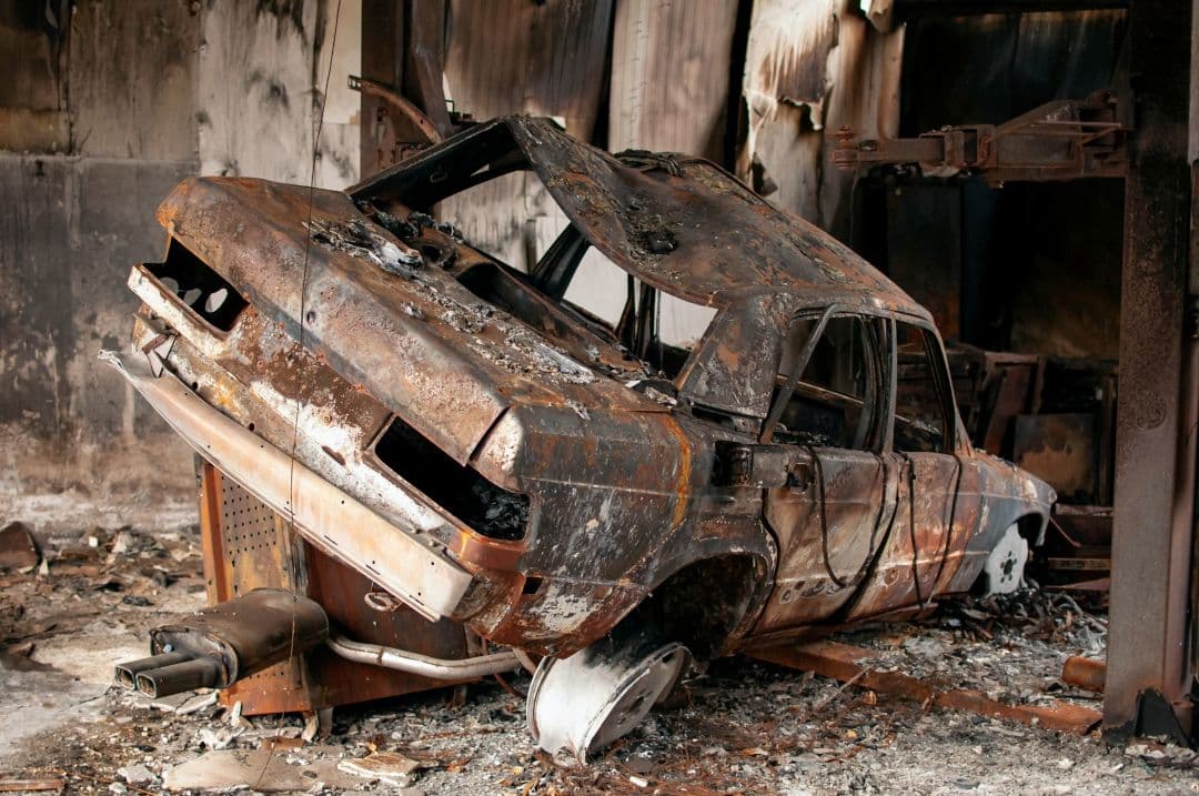 burned-out rusted car with severe fire damage