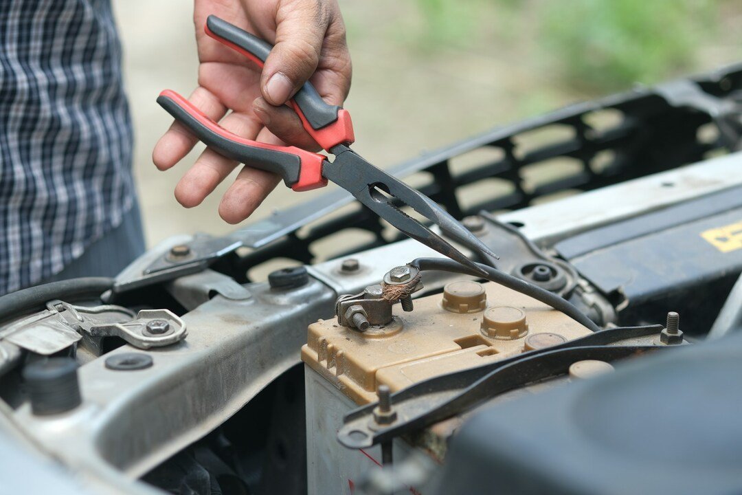 man repairing his car on the road