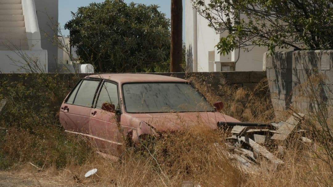 abandoned pink car with front-end damage