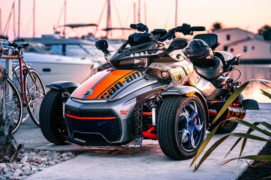 a Can-Am vehicle in front of yachts in the harbor